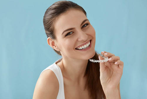 Woman holding a clear dental aligner